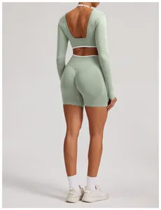 Back view of a seamless mint green long sleeve yoga top and high waist biker shorts