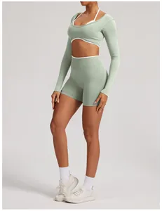 Detail of seamless long-sleeve yoga crop top and high waist shorts set in light green