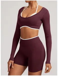 Detail view of a burgundy seamless long-sleeve yoga set featuring white trim accents.