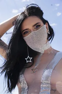 Detailansicht einer funkelnden silbernen Metallnetz-Gesichtsmaske mit Sternenanhänger-Halskette