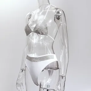 Detailed view of sexy white two-piece bikini with silver rhinestone accents