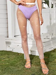 Pantalones de malla sexys con strass para mujer en un patio exterior blanco brillante