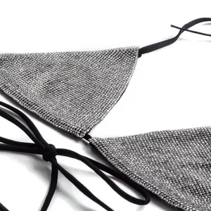 Close-up of sparkling silver rhinestones on a sexy black bikini swimsuit top