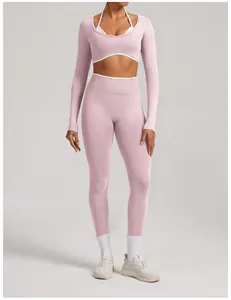 Professional pink seamless long-sleeve yoga set with high-waisted leggings on female model