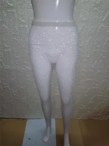 Detalle de leggings de malla blancos con adornos de diamantes de imitación brillantes.