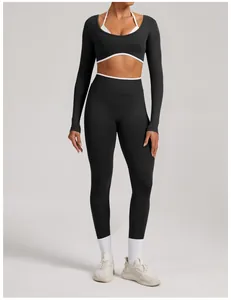 Full body view of a black seamless yoga set with white trimmed long sleeve top and leggings