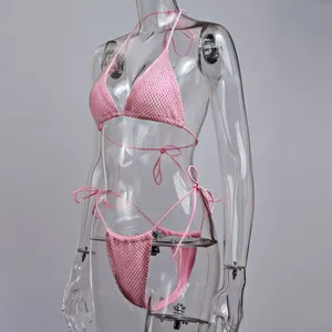 Vue latérale détaillée d'un bikini rose sexy à strass sur un mannequin transparent.