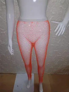 Vista detallada de los sexys pantalones de malla naranja con pedrería brillante para escenario