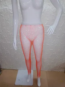 Detalle de los leggings de rejilla naranja con pedrería brillante para actuaciones.