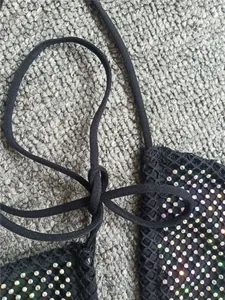 Gros plan détaillé d'un haut de bikini en résille noire avec des strass colorés étincelants