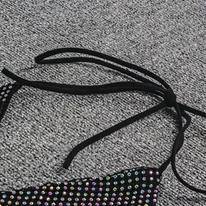 Vue détaillée des strass irisés sur un haut de bikini noir sexy avec des liens.