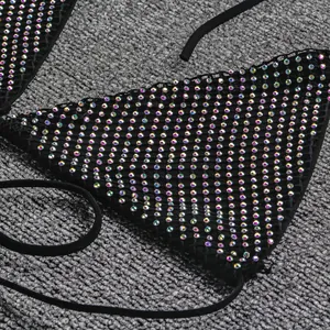 Détail rapproché d'un haut de bikini triangle noir avec des strass irisés scintillants
