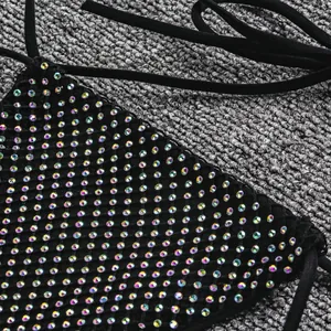 Détail en gros plan du haut de bikini noir sexy orné de strass irisés scintillants.