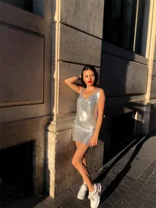 Sexy silver metallic sequin mini dress worn by a model in bright outdoor sunlight.
