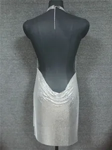 Detailed back view of a silver sequined halter dress with an elegant deep V-back design on mannequin.