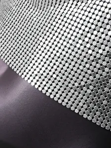 Macro detail view of silver metal sequin mesh fabric with shiny hexagonal paillettes