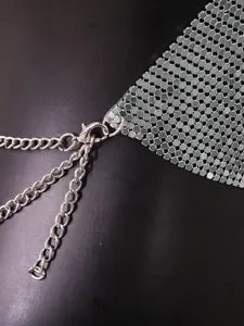 Close-up of silver metallic sequin fabric with lobster clasp and chain adjustment detail