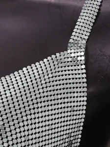 Macro detail of shimmering silver metallic sequins on a sexy nightclub chainmail top vest