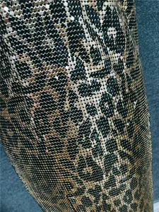 Close-up macro detail of the gold metallic sequin fabric texture on a sexy club dress