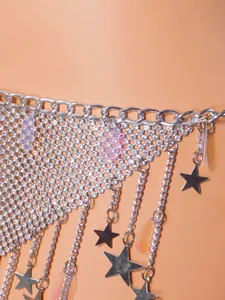 Macro view of silver mesh bikini body chain with star charms and sparkling rhinestones