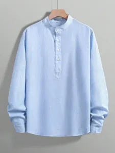 Close-up of the fine light blue striped fabric texture and stand-collar button detail