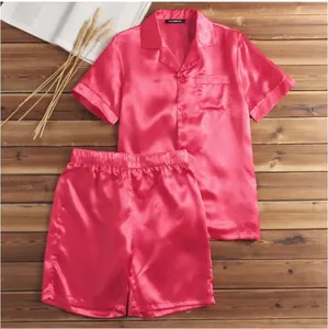 Detailed view of men's pink satin pajama set on a rustic wooden surface