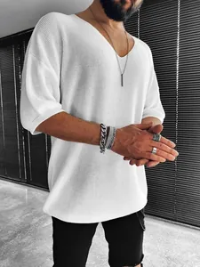 Close-up of white men's V-neck knit shirt with textured fabric and relaxed fit details