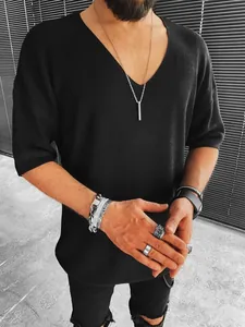 Detail view of men's black V-neck short sleeve knit shirt with silver rings and necklace
