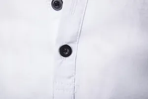 Close-up detail of black buttons and placket on a white men's casual long sleeve shirt