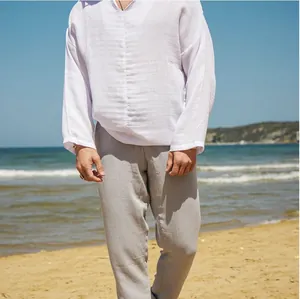 Mens casual white linen shirt and grey trousers on a sunny beach detail view photo