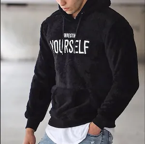 Nahaufnahme von schwarzem flauschigem Hoodie mit weißer 'Invest in yourself' Bestickung.