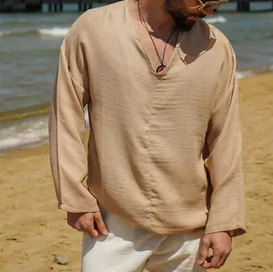 Detail of a men's solid beige linen shirt with a V-neck on a beach setting