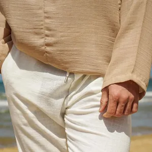 Macro detail shot showing the fabric texture of men's linen shirt and white trousers