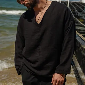 Stylish men's black linen long-sleeve shirt with V-neck detail shown in beach setting