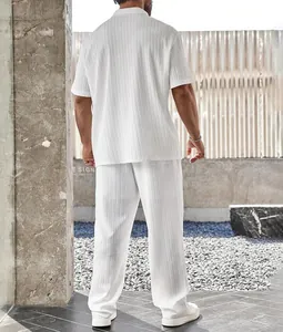 Vista trasera del conjunto plisado blanco para hombre con camisa y pantalón largo.