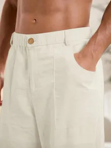 Dettaglio ravvicinato di pantaloni casual da uomo in cotone e lino con bottone in legno