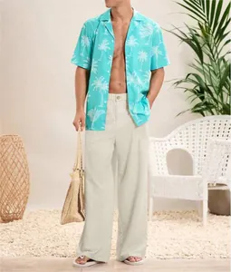 Uomo che indossa pantaloni di lino beige larghi in un ambiente tropicale da resort