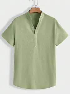 Detail view of a men's light green textured short sleeve shirt with v-neck collar design.
