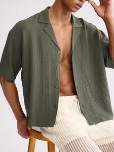 Macro view of olive green textured men's short sleeve lapel shirt in a loose fit