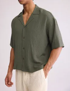 Close-up detail of olive green textured fabric on men's short sleeve camp collar shirt