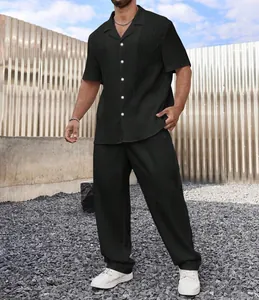 Detalle de un conjunto de hombre negro con camisa de manga corta y pantalón texturizado.