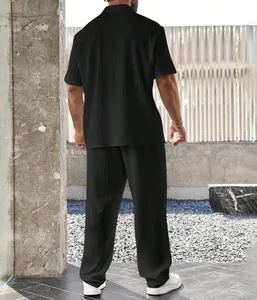 Vista trasera de una camisa de manga corta plisada negra y pantalones largos para hombre