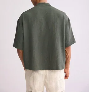 Detailed back view of men's loose short sleeve shirt with textured olive fabric