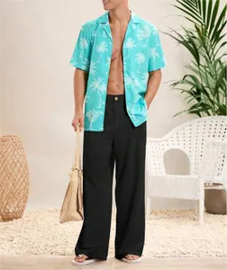 Pantaloni casual larghi in cotone e lino nero da uomo in un ambiente da resort tropicale