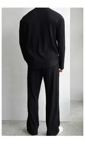 Back view of men's black pleated set showing premium vertical texture and relaxed fit.