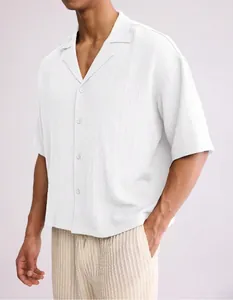 Detail view of men's loose white short-sleeve shirt with textured fabric and lapel
