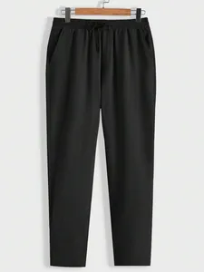 Minimalist black textured men's casual trousers featuring an elastic drawstring waist.