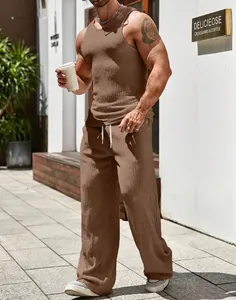 Outdoor street view of a men's brown ribbed tank top and wide-leg trousers set