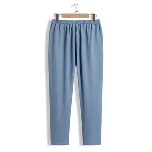 Vue de face d'un pantalon décontracté bleu pour homme suspendu à un cintre en bois.