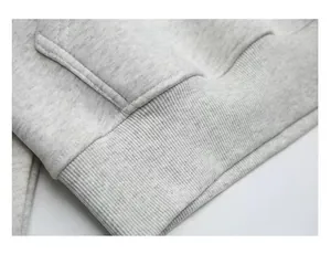Close-up of ribbed hem and pocket detail on a heavyweight grey cotton hoodie